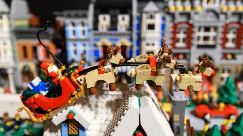 Image of Lego Santa Claus flying his Lego sleigh with his reindeer, including Rudolph.