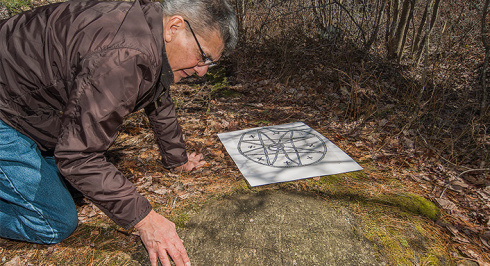 Curator looking at a petroglyph 