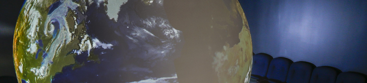 Four children looking at Earth projected on Science on a Sphere.